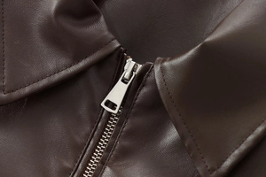 Detailed close-up of dark brown faux leather aviator jacket showing silver zipper and stitching