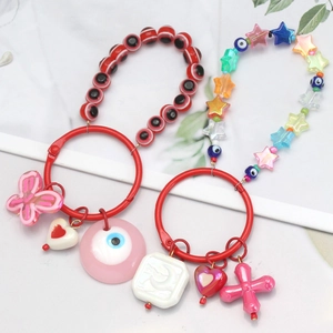 Close-up of DIY colorful beaded phone chains with evil eye charms and butterfly pendants