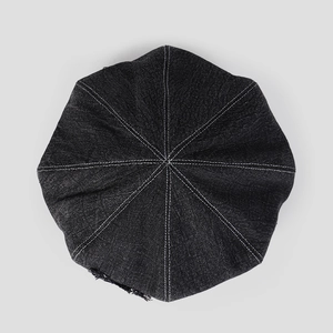 Top view of denim newsboy cap showing eight-panel stitching and white contrast seams