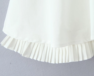 Vue détaillée de l'ourlet à volants plissés blancs et de la texture du tissu tissé