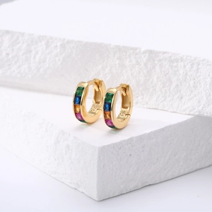 Détail macro de boucles d'oreilles créoles en argent S925 doré avec pierres colorées