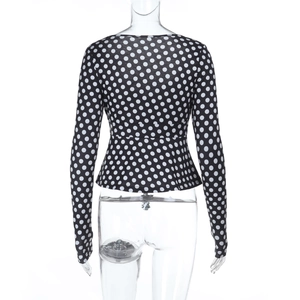 Vista posteriore di un crop top aderente a maniche lunghe con motivi a pois bianchi e neri