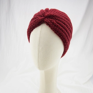 Detailed knit texture of burgundy twist headband on model with white background