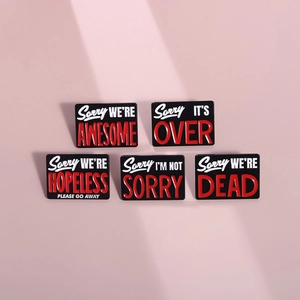 Set of 5 black geometric enamel pins with motivational quotes on soft pink background