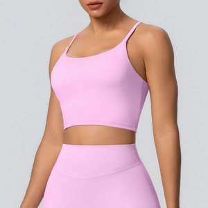 Gros plan sur un soutien-gorge de yoga rose clair à fines bretelles et un legging assorti