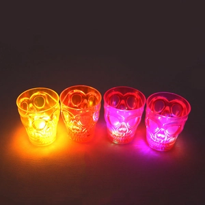 Row of four glowing skull-shaped mini glasses in yellow, orange, and purple LED colors