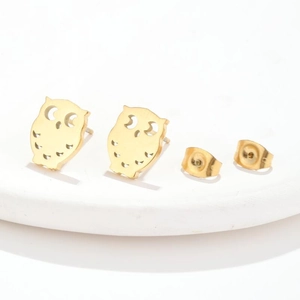 Close-up of golden owl stud earrings featuring intricate hollow details and secure backs