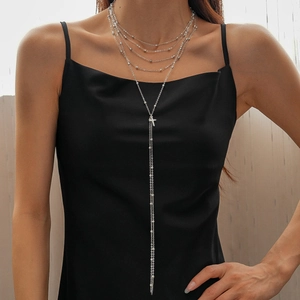 Silver multi-layer lariat necklace with small beads and delicate cross pendant on model