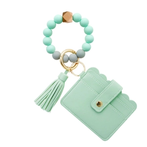 Detail of mint green silicone bead bracelet with PU leather card holder and tassel keychain