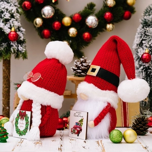 Close-up of knit Christmas gnomes holding festive cards with Christmas wishes greeting
