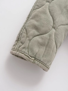 Détail de la veste matelassée en coton vert sauge avec finitions aux poignets