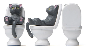Three-sided view of gray cat figurine sitting on white toilet for desktop decoration