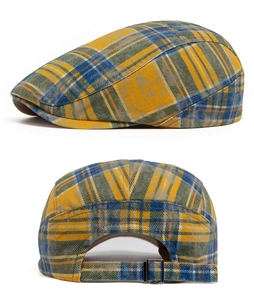 Detail view of yellow plaid newsboy hat with metal buckle and fabric texture
