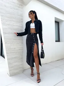 Détail de jupe mi-longue en jean à taille haute avec fente irrégulière et boutons en métal