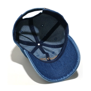 Detail of blue denim baseball cap interior featuring reinforced seams and metal buckle