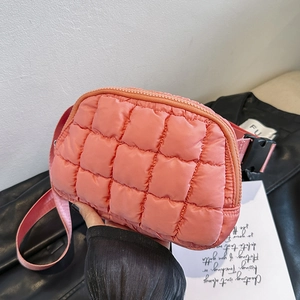 Detailed view of a pink quilted puffer waist bag featuring an adjustable strap and buckle