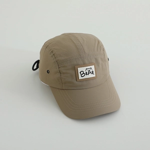 Detail of khaki quick-dry camper hat featuring breathable metal eyelets and bear patch