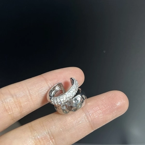 Macro detail of silver ear cuff set with pavé cubic zirconia and hammered metal texture