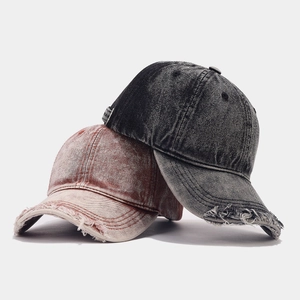 Close-up of vintage washed denim baseball caps with distressed ripped brim details