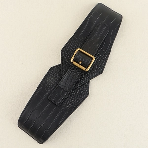 Close-up of black wide waist belt with faux crocodile pattern and golden square metal buckle