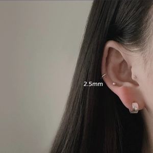 Close-up of minimalist silver hoop earrings and 2.5mm bead stud on model's ear