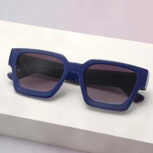 Detail view of bold royal blue square sunglasses on a geometric display block