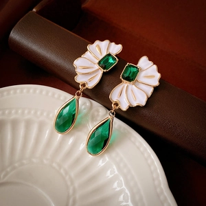 Vue macro de boucles d'oreilles vintage en cristal vert émeraude avec détails de fleurs