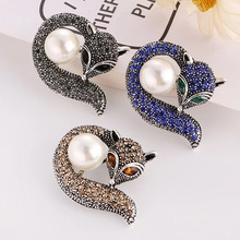 Detailed view of three fox brooches with colorful rhinestones and large white pearls