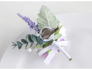 Detail of lavender boutonniere back featuring a safety pin and metal hair clip fastener