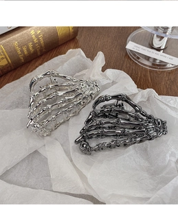 Detail of gothic skeleton hand hair claws in silver and gun-black metal finishes