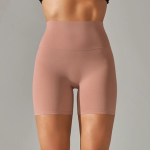 Detail view of high-waisted yoga shorts in coral pink with seamless matte finish