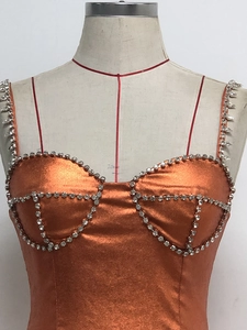 Detail eines orangefarbenen Metalltops mit Strassbesatz und gepolsterten Körbchen