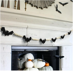 Halloween black bat tag with natural wood beads hanging on a white fireplace mantel