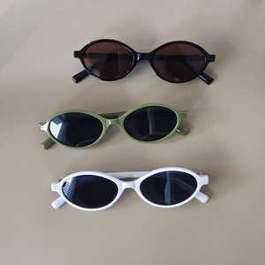 Kids narrow oval sunglasses in black, avocado green, and white stylish plastic frames