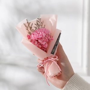 Close-up of mini dried flower bouquet with pink carnations and Best Wishes label