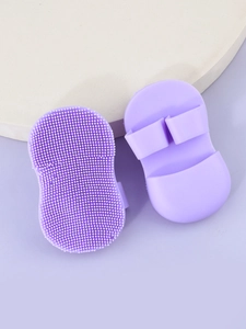 Detail of purple silicone face brushes with soft bristles and finger grip loop