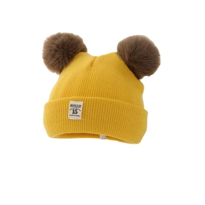 Thick yellow knit baby winter hat with two large brown pom-poms and front woven patch