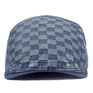 Close-up of blue checkerboard denim flat cap showing premium canvas texture and stitching