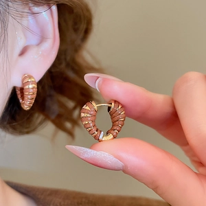 Vue détaillée de boucles d'oreilles créoles torsadées en forme de cœur en or 18 carats