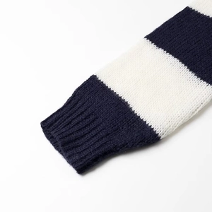 Detailed close-up of ribbed cuffs on a navy blue and white striped knit sweater