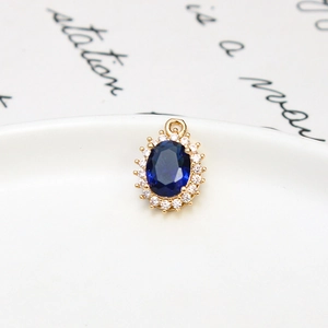 Detailed view of an oval blue crystal pendant with micro-pave zircon and a gold-plated rim
