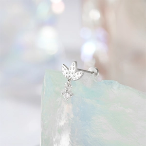 Detailed macro view of 925 sterling silver bow knot earring with inlaid zircons on salt stone