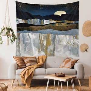 Abstract mountain wall tapestry with gold peaks and blue moon in a cozy living room scene