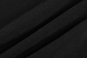 Close-up of black dress fabric showing premium granular texture and soft drape detail