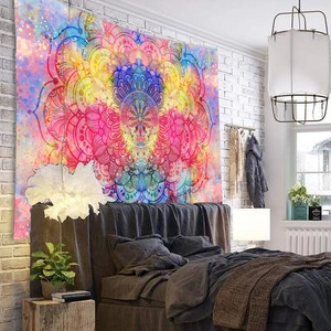 Bohemian mandala tapestry with vibrant pink and blue patterns displayed over a bed