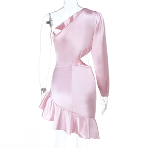 Détail d'une robe en satin rose avec coupe asymétrique, découpe taille et ourlet volanté