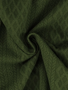 Macro detail of dark olive green fabric featuring a unique textured diamond jacquard pattern