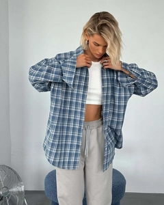 Detail of oversized blue and white plaid flannel shirt with loose long sleeves