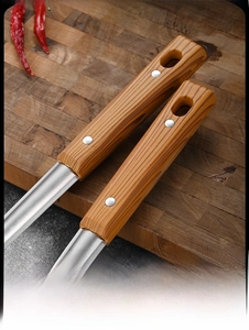 Detailed macro view of ergonomic wood-grain handle with hanging hole on steel spatula