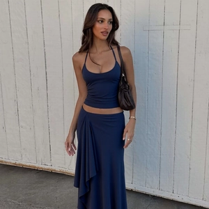 Detail view of high-waist navy blue maxi skirt with elegant side pleats and ruffles